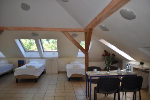 a living room with a table and a room with beds at Pod starymi lipami in Szczecin