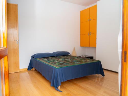 a bedroom with a bed with a blue bedspread and yellow cabinets at Il Campanile in Vico Equense