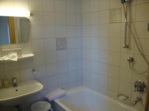 a bathroom with a tub and a sink and a shower at Alpengasthof Rossmoos in Alpbach