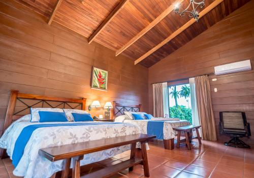 a bedroom with two beds in a room with wooden walls at Hotel El Silencio del Campo in Fortuna