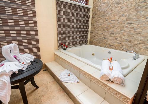 a bathroom with a tub and a table with towels at Hotel El Silencio del Campo in Fortuna