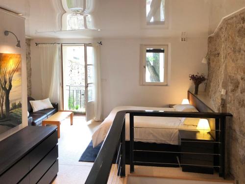 1 dormitorio con 1 cama y 1 sofá en una habitación en Villa Authentique et Architecturale - Centre Ville, en Forcalquier