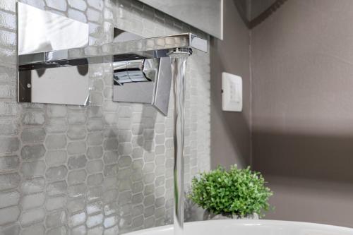 a bathroom with a sink with a faucet at A World Aparts - Barberini Boutique Hotel in Rome