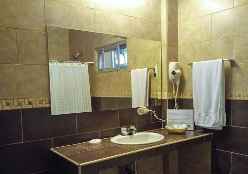 y baño con lavabo y espejo. en Real Guanacaste, en San Pedro Sula