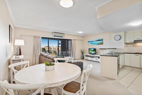 a kitchen and living room with a table and chairs at Rovera Apartments in Maroochydore