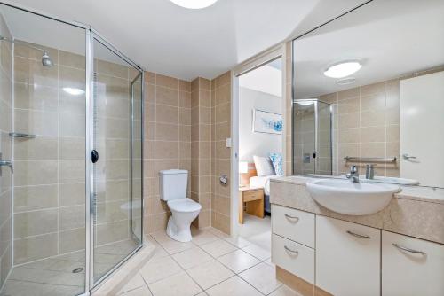 a bathroom with a shower and a sink and a toilet at Rovera Apartments in Maroochydore
