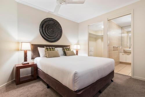 a bedroom with a large bed and a bathroom at Rovera Apartments in Maroochydore