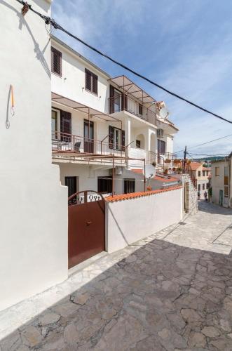 a white house with a gate and a fence at Apartment Murva in Primošten