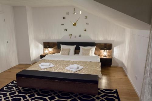 1 dormitorio con 1 cama grande y reloj en la pared en Vacation home, en Sarajevo
