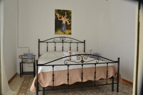 a bedroom with a black bed with a painting on the wall at Gocce Siciliane Apartments in Porto Empedocle