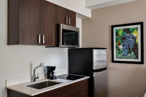 a kitchen with a sink and a refrigerator at Coast Oliver Hotel in Oliver