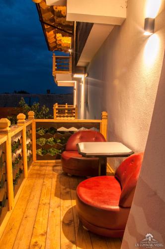 a balcony with a table and chairs on a deck at La Conacul Vesel Săpânța in Săpînţa