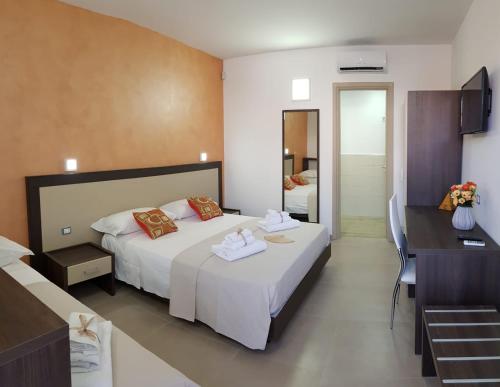 Cette chambre comprend un grand lit et un bureau. dans l'établissement Sole del Sud, à Torre San Giovanni