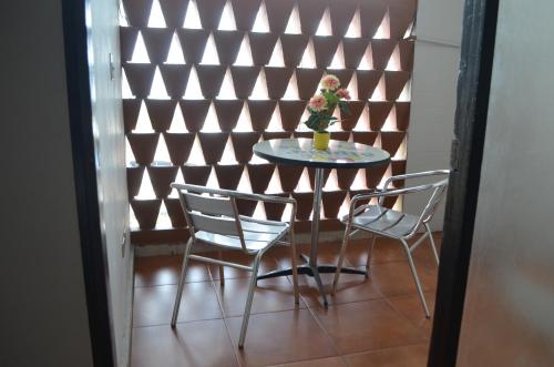 a table and chairs in a room with a wall at Hotel Caribe Panamá in Panama City
