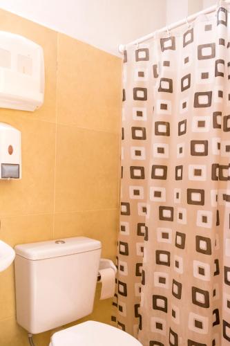 a bathroom with a toilet and a shower curtain at Hostal Alamo in Cafayate