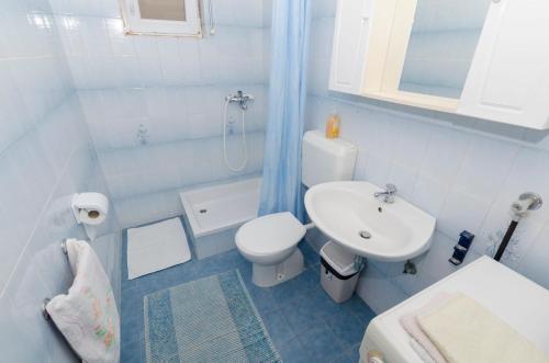 a bathroom with a white toilet and a sink at Apartments Biserka in Primošten