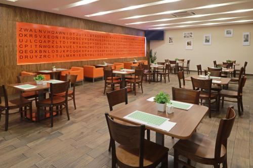 a restaurant with tables and chairs in a room at Wyndham Garden Guadalajara Acueducto in Guadalajara