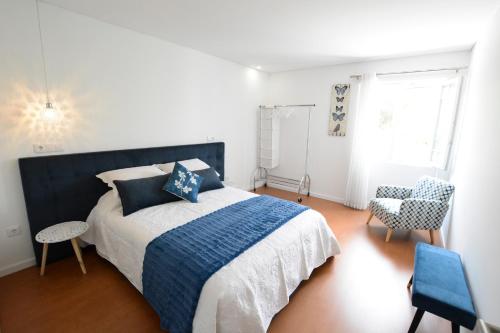 a bedroom with a blue and white bed and a chair at LUXURY Golden River Apartment - In the Heart of city center and wine cellars in Vila Nova de Gaia