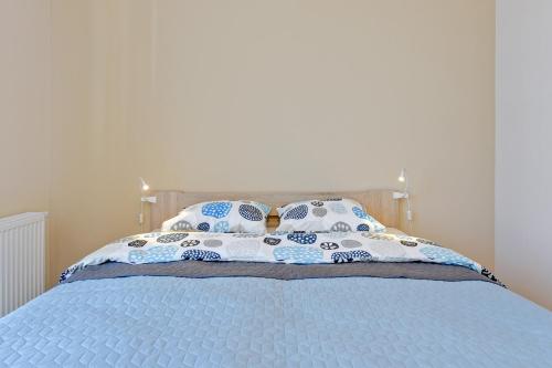 a bed with blue and white sheets and pillows at INA Rent - Tre Mare Apartamenty in Gdańsk