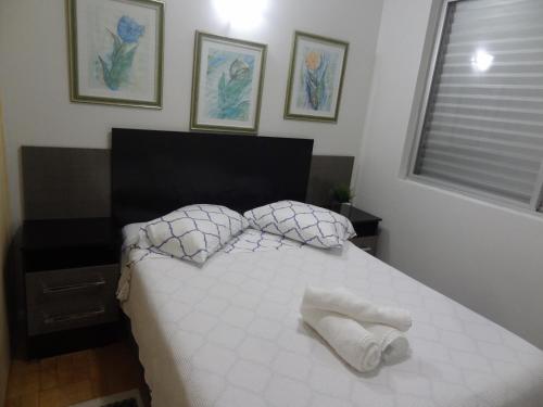a bedroom with a white bed with two pillows at Apartamento Beira mar in Arroio do Silva