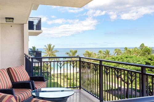 a balcony with chairs and a view of the ocean at Fifth Floor UPGRADED Villa with Sunset View - Beach Tower at Ko Olina Beach Villas Resort in Kapolei
