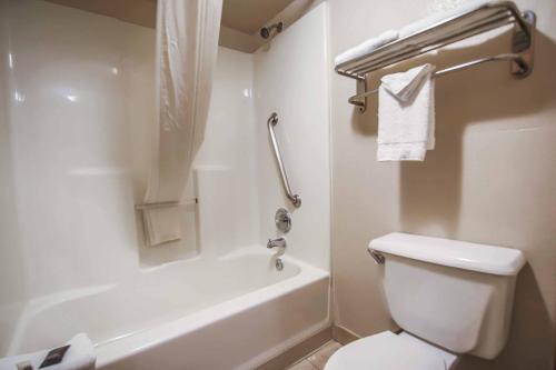 a bathroom with a white toilet and a tub and a sink at Sunrise Inn in Las Vegas