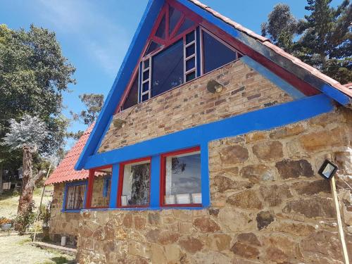 a house with a blue roof at Cabañas Yukatan Lago de Tota in Tota
