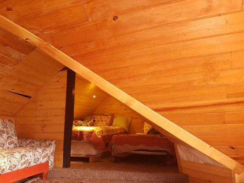 a room with a bed in a wooden attic at Cabañas Yukatan Lago de Tota in Tota