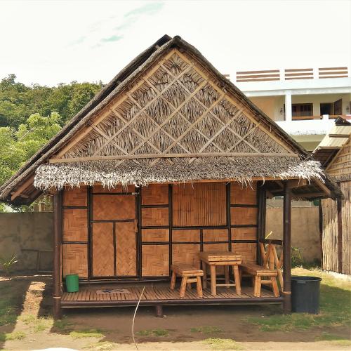 a small hut with a table and chairs in it at Magindara Guesthouse in Caramoan