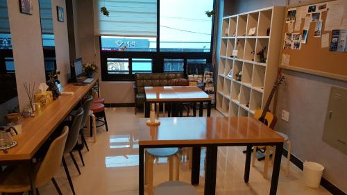 a restaurant with tables and chairs and a guitar at O'guest in Haeundae in Busan