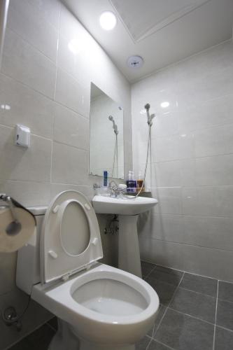 a white bathroom with a toilet and a sink at O'guest in Haeundae in Busan