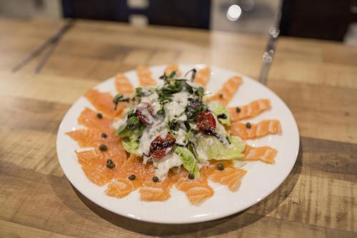 a plate of pasta and vegetables on a wooden table at O'guest in Haeundae in Busan