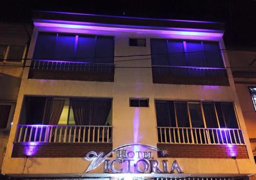 a building with purple lights on the side of it at Hotel Victoria in Chinchiná
