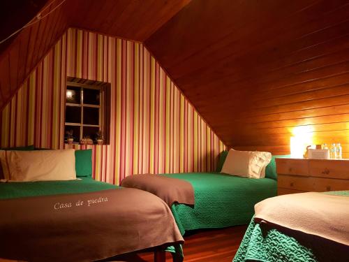 a small room with two beds in a attic at Cabañas Yukatan Lago de Tota in Tota