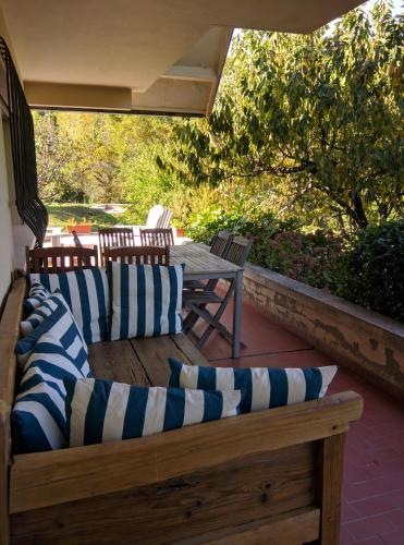 a patio with a wooden bench and a table with pillows at Puente Canto de Gredos in Arenas de San Pedro