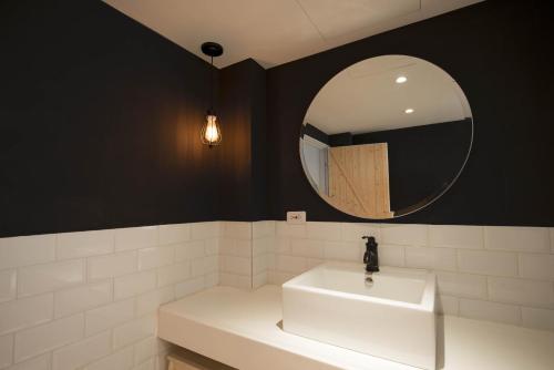 a bathroom with a white sink and a mirror at 被愛咖啡小旅館 Birdeye Garden in Tainan
