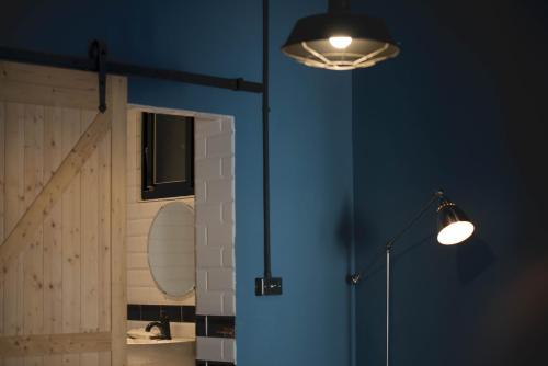 a room with two lights and a blue wall at 被愛咖啡小旅館 Birdeye Garden in Tainan