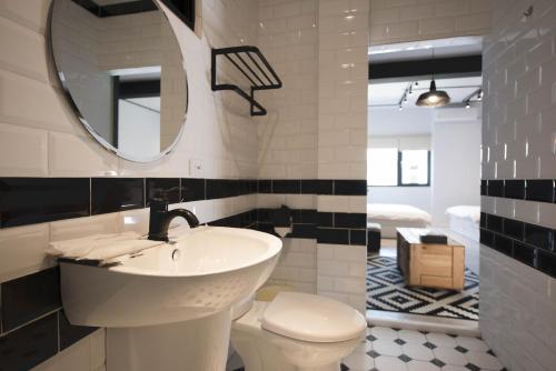 a bathroom with a sink and a toilet and a mirror at 被愛咖啡小旅館 Birdeye Garden in Tainan