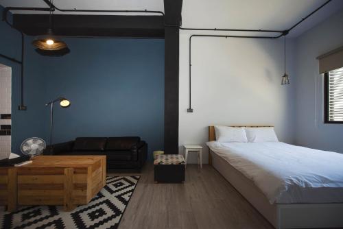 a bedroom with a bed and a couch at 被愛咖啡小旅館 Birdeye Garden in Tainan