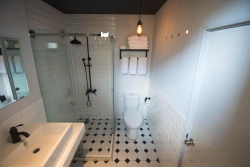 a bathroom with a toilet and a shower and a sink at 被愛咖啡小旅館 Birdeye Garden in Tainan