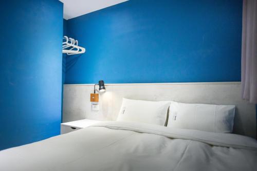 a bedroom with a blue wall and a bed at We Come Hostel in Taipei
