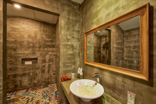 a bathroom with a sink and a mirror at Mane Village Suites in Siem Reap