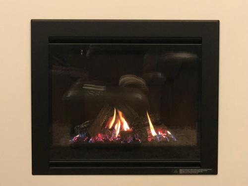 a camera and a fire in a fireplace at Otaki Beachfront Getaway in Otaki Beach