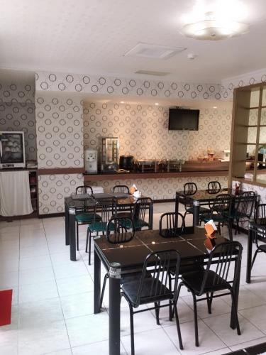 a dining room with tables and chairs and a kitchen at Treasure Island Motel - Renwu in Kaohsiung