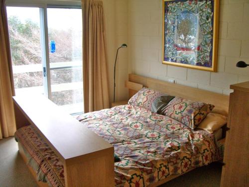 a room with a bed and a table and a window at Maisonette, Falls Creek in Falls Creek