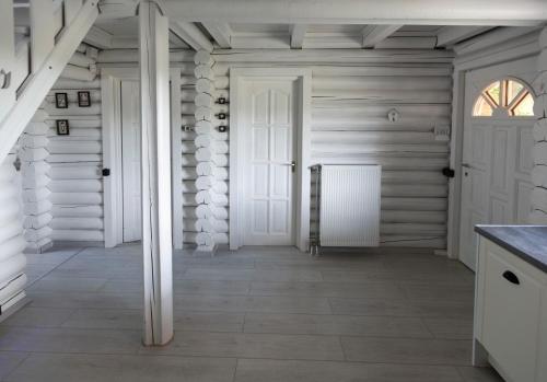 a hallway with white walls and a door at Öböl Liget vendégházak in Abádszalók