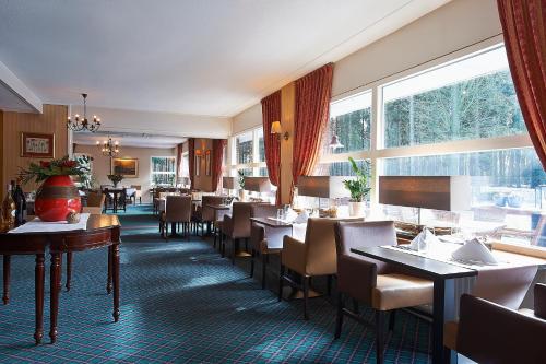 Hotel-Restaurant Ruyghe Venne في فيستبورك: مطعم بطاولات وكراسي ونافذة كبيرة