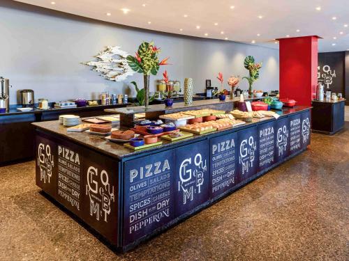 a buffet line with food on it in a restaurant at Novotel Sao Paulo Center Norte in Sao Paulo