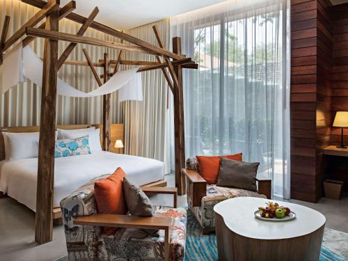 a hotel room with a bed and a couch and a table at SO/ Sofitel Hua Hin in Cha Am