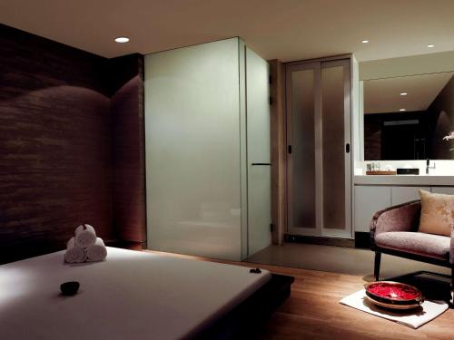 a bedroom with a bed and a glass wall at Pullman New Delhi Aerocity in New Delhi
